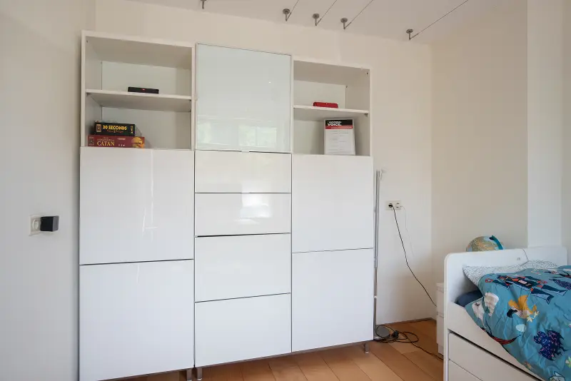 Kinder- of logeerkamer met ruime witte kastwand en bed