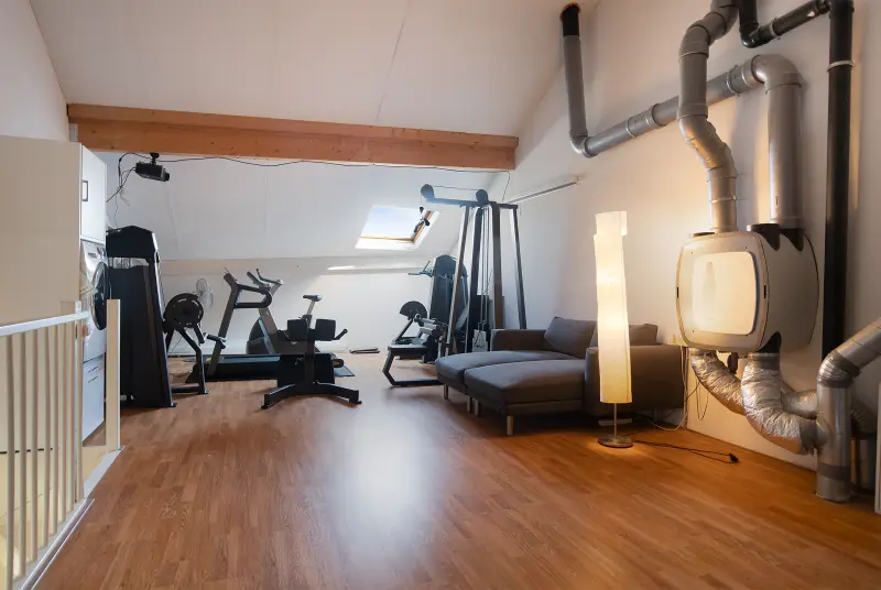 Ruime zolderverdieping met hoge nok, nu ingericht als fitnessruimte